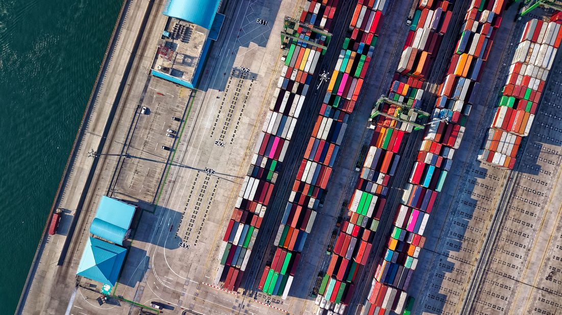 Aerial view of colorful shipping containers stacked at a port terminal